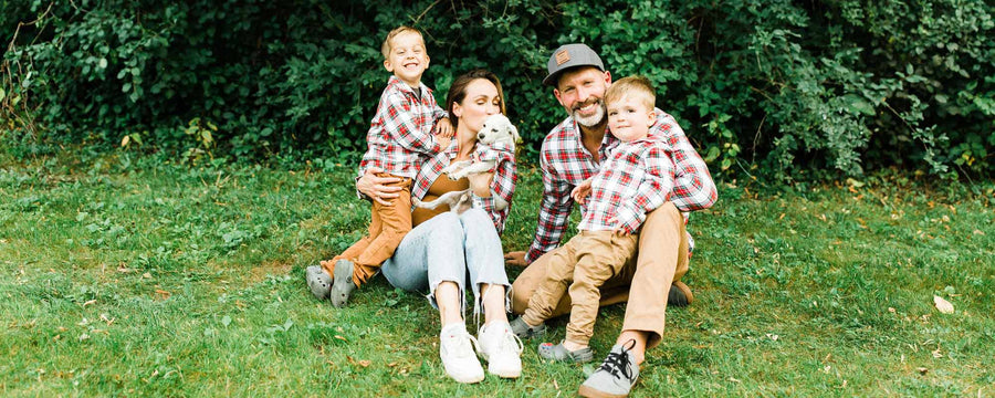 family with two kids and a small dog in matching flannels