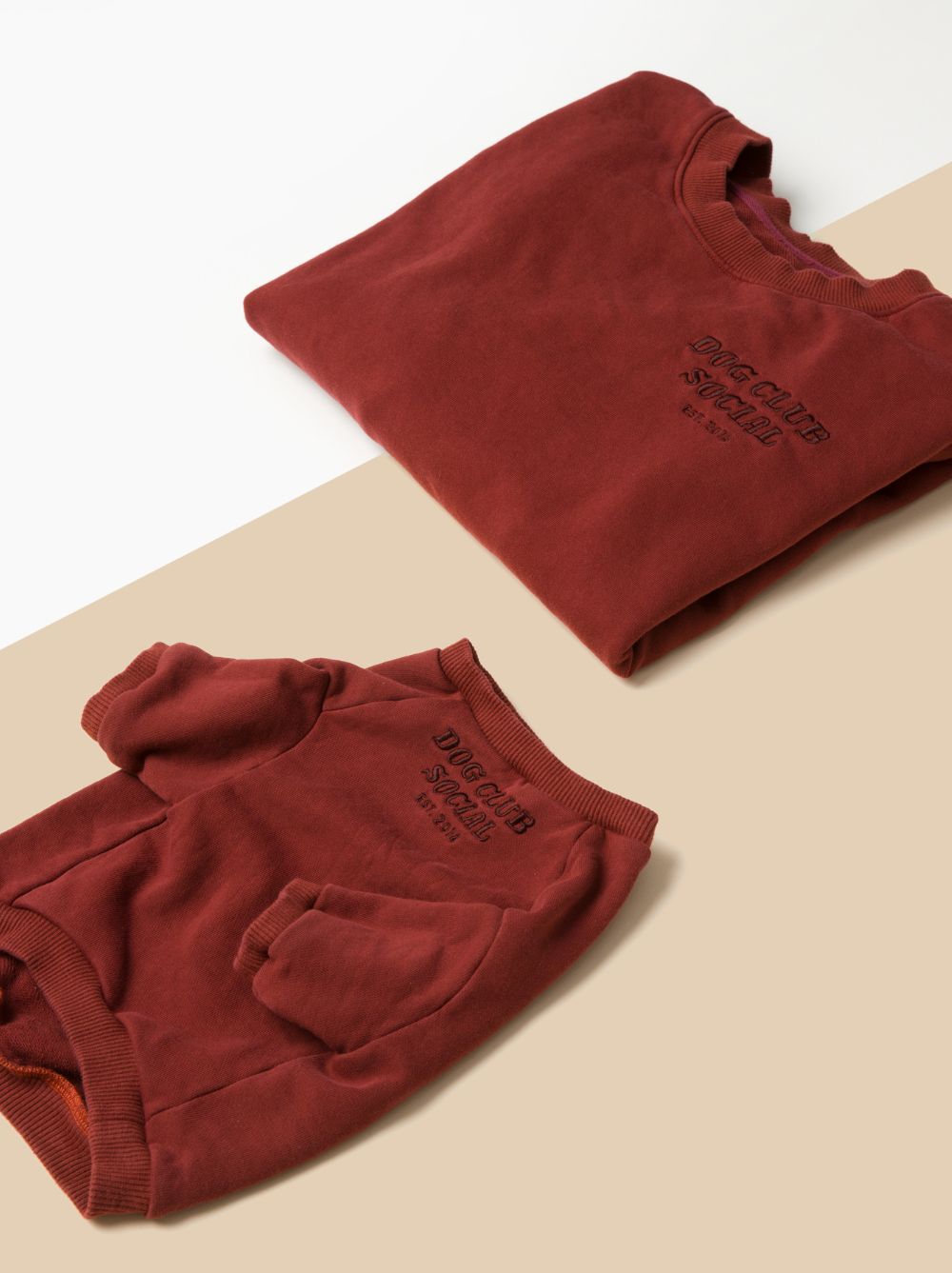 flatlay of human and dog maroon terry pullovers on white and tan backdrop